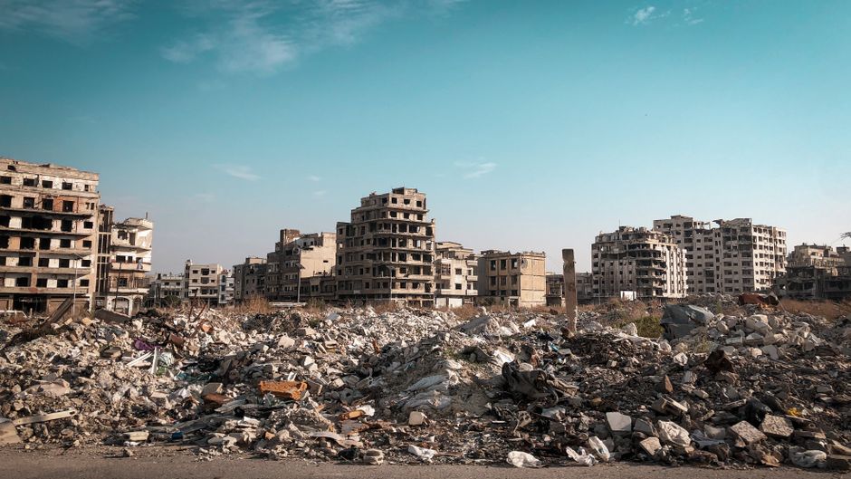 View of demolished buildings and rubble in Homs, Syria post-conflict.