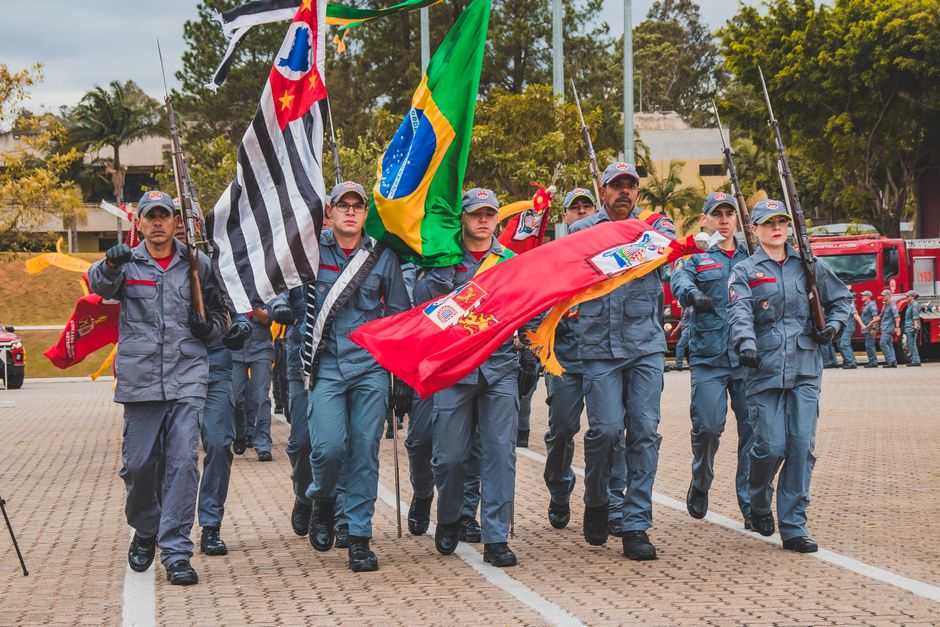 Brazilian military officers march with flags during a ceremonial parade showcasing patriotism and unity.