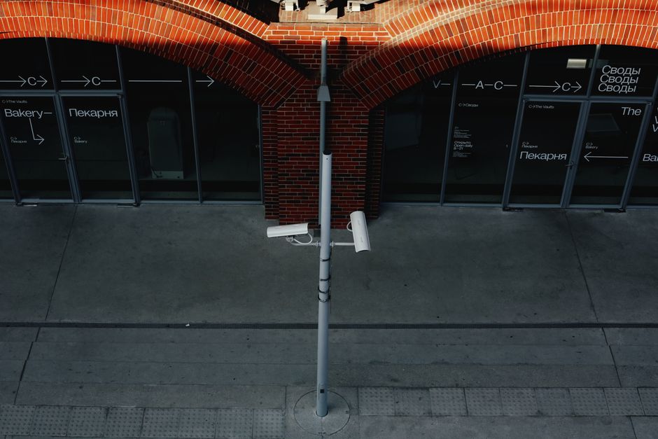 Street view with security cameras and an urban industrial building facade.