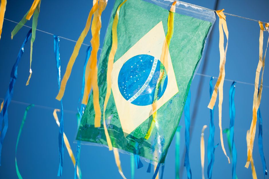 A Brazilian flag decorates the scene with colorful hanging ribbons celebrating national pride.