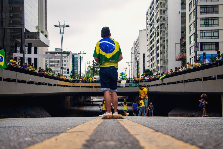 Street gathering in Brazil with people celebrating and wearing national flags.