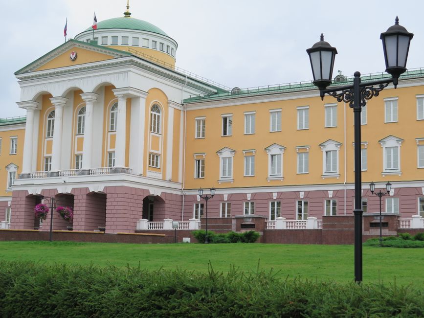 Stunning neoclassical architecture with tall columns and lush green lawn.