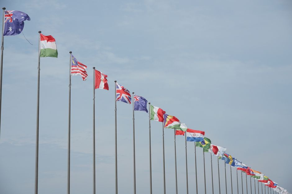 A row of international flags on flagpoles symbolizing global unity and diplomacy.