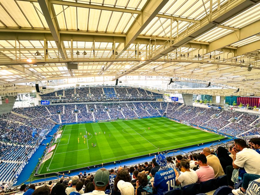 A lively football match underway at Porto's iconic Estádio do Dragão, packed with enthusiastic fans.