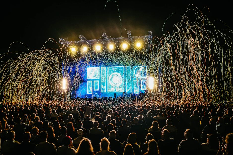 Dynamic live music concert with vibrant stage lights and a lively crowd enjoying the night.