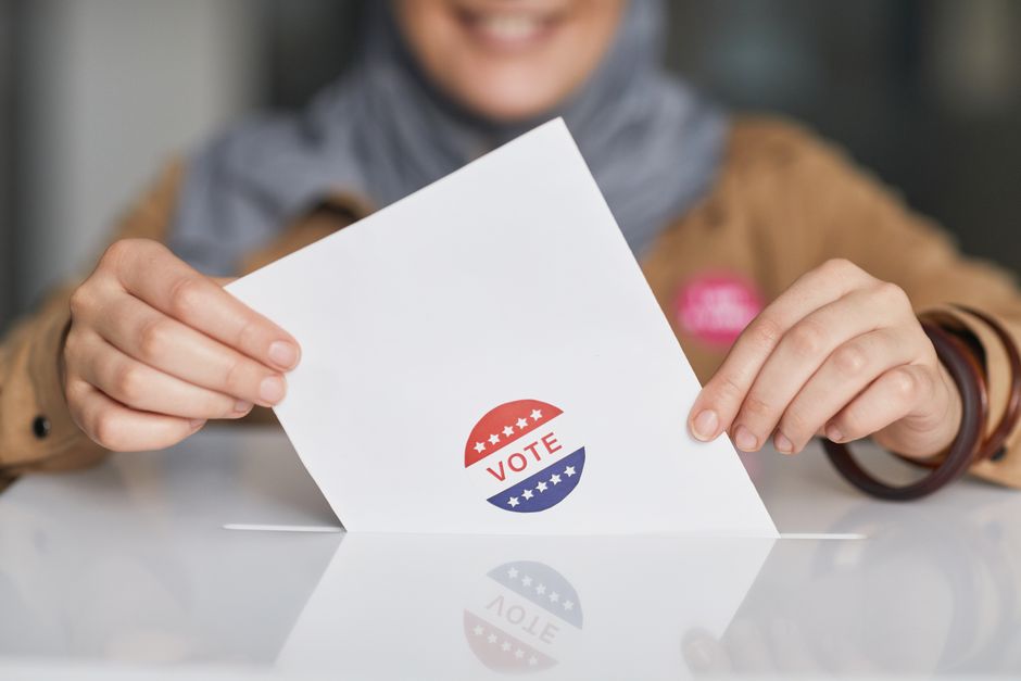 Close-up of hands holding a vote ballot, symbolizing election participation.