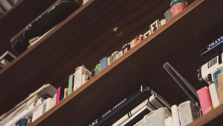 Low angle view of assorted books on wooden shelves indoors. Perfect for educational or literary themes.