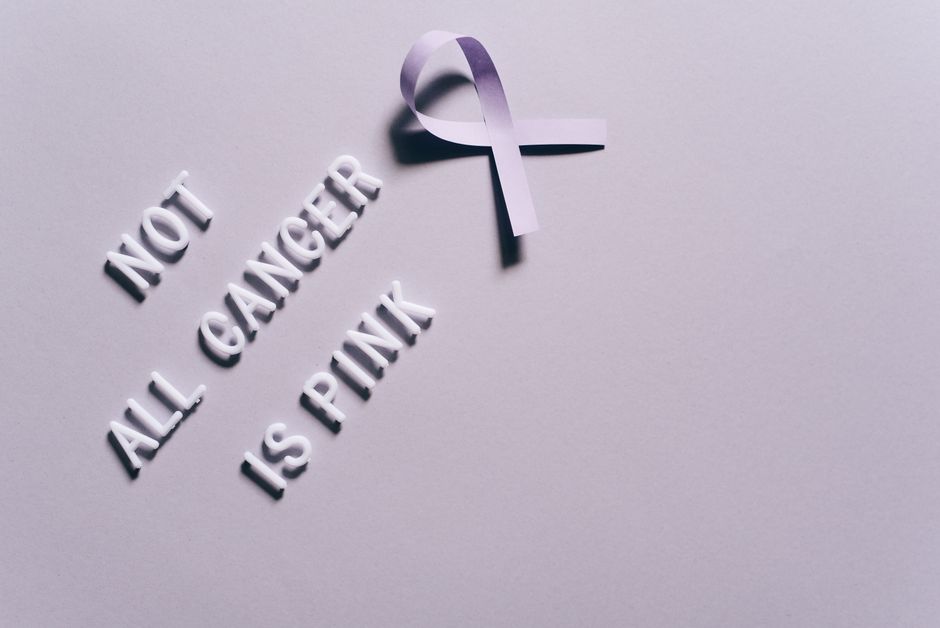 Cancer awareness poster with a purple ribbon on a gray background.