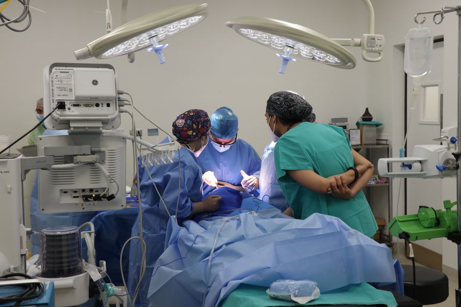 Team of surgeons operating in a well-equipped surgical room.