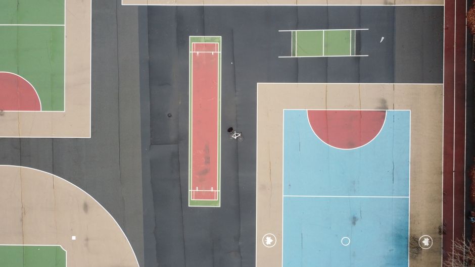 Colorful sports courts captured from above in Brooklyn's urban setting.